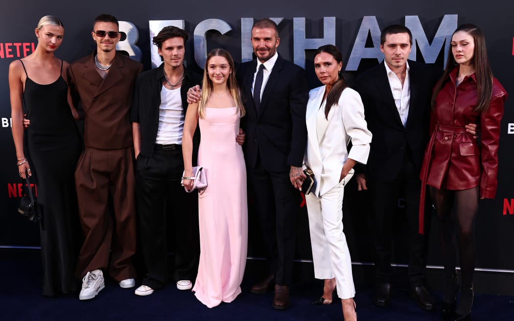 Former England footballer David Beckham (5L) and his wife Victoria Beckham (3R) pose on the red carpet with their children, and partners, (from L) Mia Regan, Romeo Beckham, Cruz Beckham, Harper Beckham, Brooklyn Beckham and Nicola Peltz Beckham upon arrival to attend the Premiere of "Beckham" in London on October 3, 2023. (Photo by HENRY NICHOLLS / AFP)