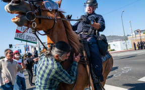 LAPD officers on horseback clash with protesters during protests after a series of immigration raids in Los Angeles.
