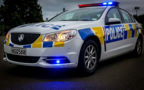 A police patrol car, with emergency lights on.