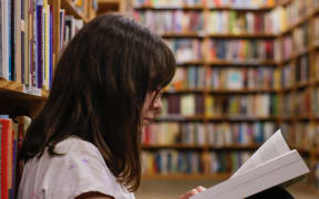 Image of girl reading in a library