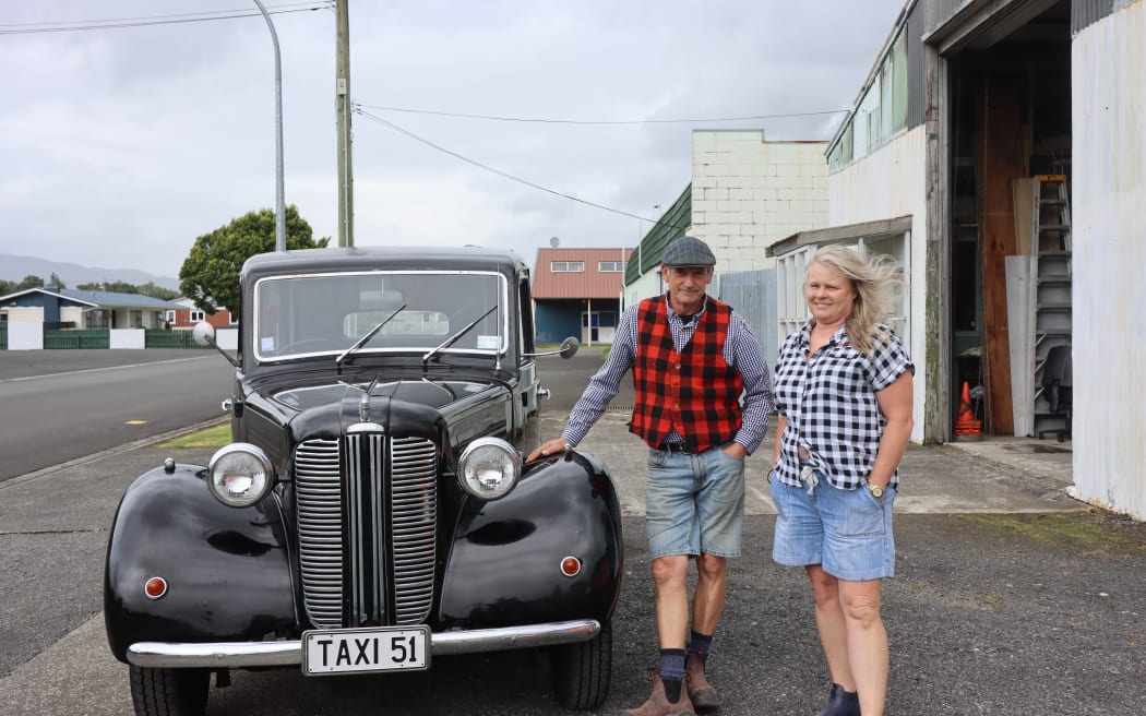 Picture of a man and woman posing next to a 1951 London Taxi.
