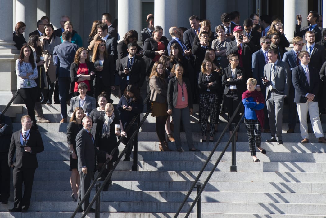 White House staffers stand on the steps of the Eisenhower Executive Office Building as they await the arrival of President-elect Donald Trump for a meeting with President Barack Obama.