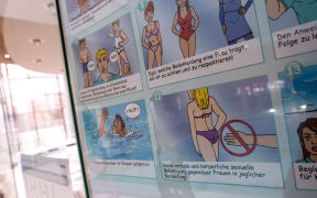 A poster informs about pool rules in a public swimming pool in Germany.