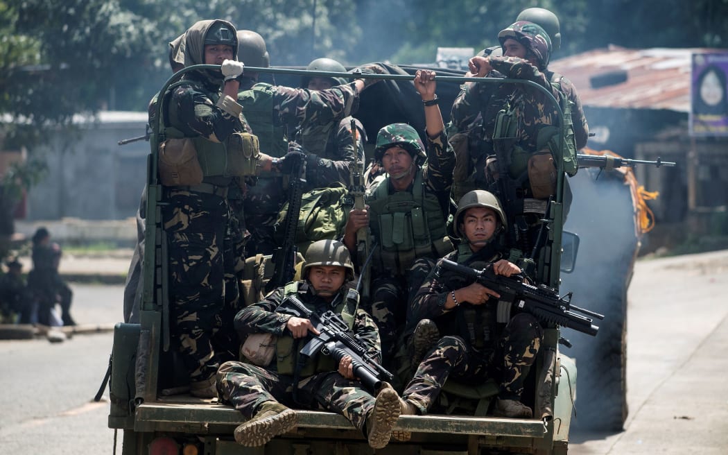 Soldiers aboard their vehicles manoeuvre through a street in Marawi, on the southern island of Mindanao, on Saturday.