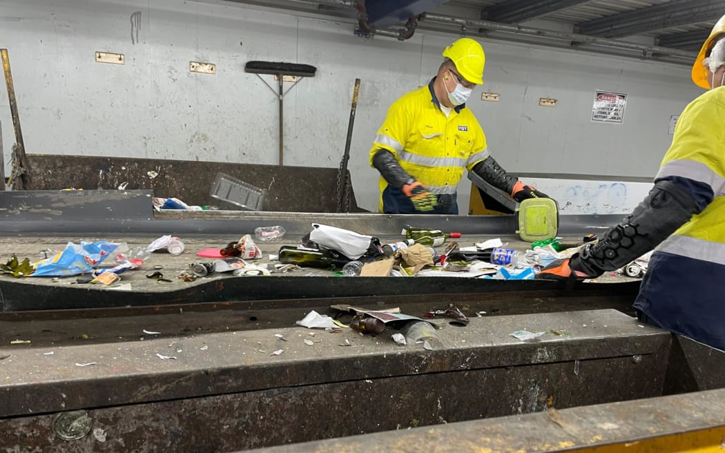 A worker manually sorts the recycling that's come through at Onehunga-based recovery facility used by Auckland Council