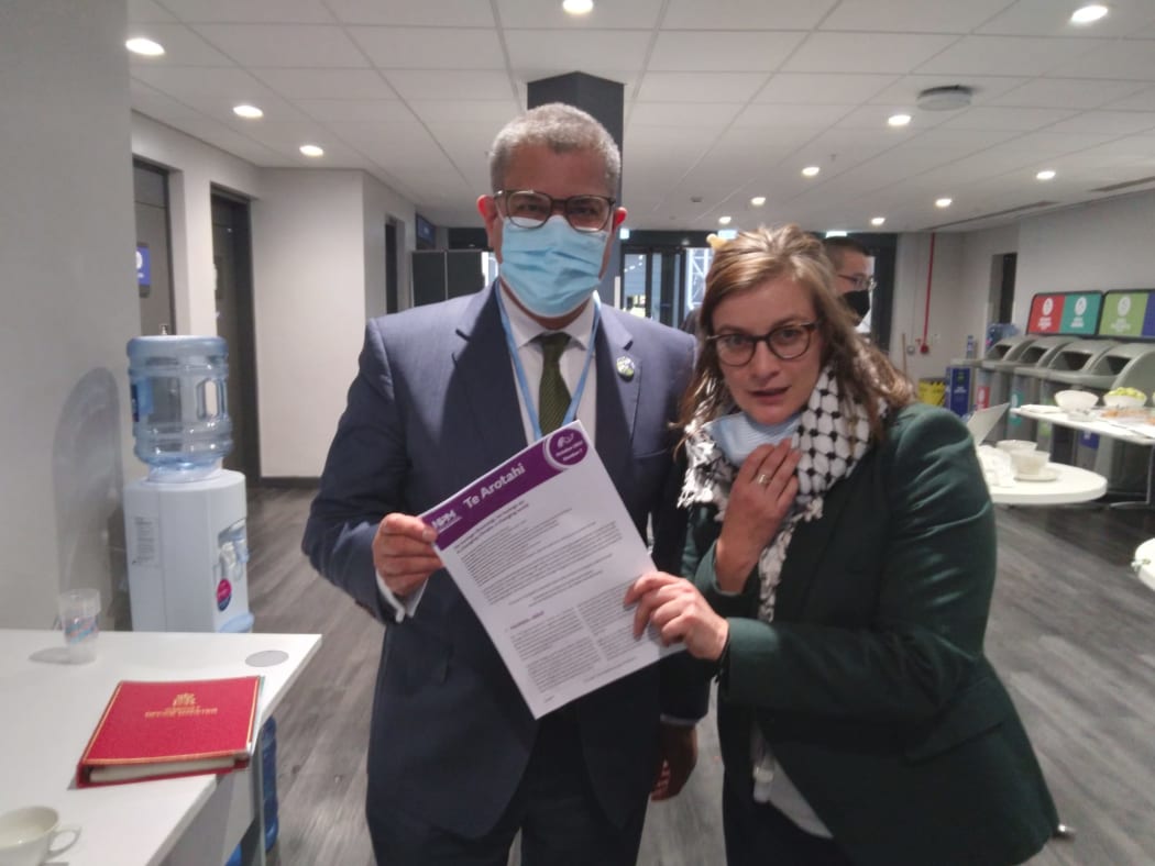 Alison Anitawaru Cole hands reports to COP26 president Alok Sharma that show the impact of climate change on indigenous communities in Aotearoa.