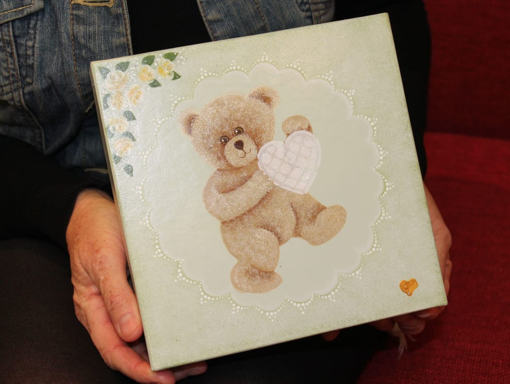 A photo of a memory box, a wooden box with a teddy bear on it. Karlena Kelliher makes them for parents who have lost an infant.
