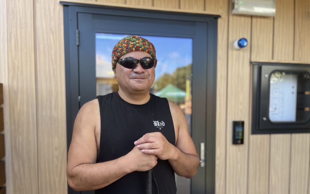 Ivan Te Momo stands in front of his new Kāinga Ora house, after two years spent in Emergency Housing