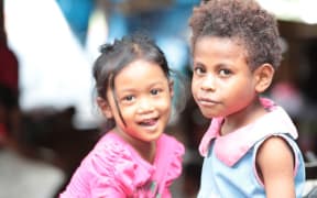 Indonesian and West Papuan girls play in a market in Jayapura.