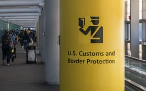 U.S. Customs and Border Protection CBP sign, inscription and symbol in yellow background in Newark Liberty International Airport EWR serving the New York Metropolitan area with arriving passenger walking in the terminal towards the immigration passport control. United States Customs and Border Protection is the largest federal law enforcement agency of the United States Department of Homeland Security with agents and officers, it's the primary border control organization. Newark, United States of America on November 2024 (Photo by Nicolas Economou/NurPhoto) (Photo by Nicolas Economou / NurPhoto via AFP)