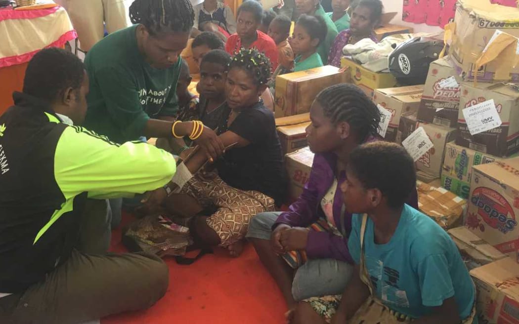 A volunteer doctor tends to a woman's broken arm, Wamena, Papua.