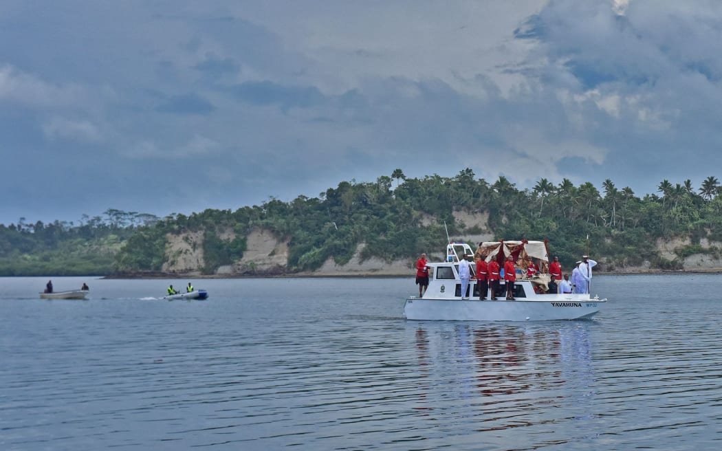 The body of the former vice president of Fiji, Ratu Joni Madraiwiwi, arrives on the chiefly island of Bau on Thursday, flanked by military guards.