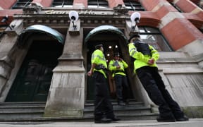 Police officers stand on duty following a raid at Granby House, close to Manchester Piccadilly railway station in Manchester.