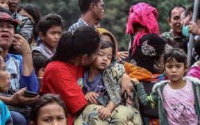Family members gather as they wait for rescue teams searching for missing passengers at the Lake Toba ferry port in the province of North Sumatra.