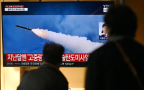 People watch a television screen showing a news broadcast with file footage of a North Korean missile test, at a train station in Seoul on October 31, 2024. - North Korea on October 31 fired a "long-range ballistic missile", South Korea's military said, Pyongyang's first weapons test since Seoul accused it of sending tens of thousands of soldiers to Russia. (Photo by JUNG YEON-JE / AFP)