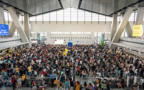 Passengers wait for information about their flights at terminal 3 of Ninoy Aquino International Airport in Pasay, Metro Manila on January 1, 2023.