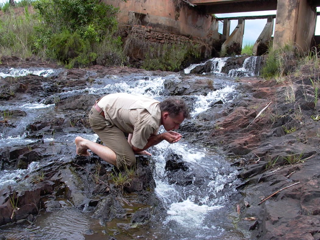 Kennedy Warne drinking from the headwaters of the Okavango River, 2003