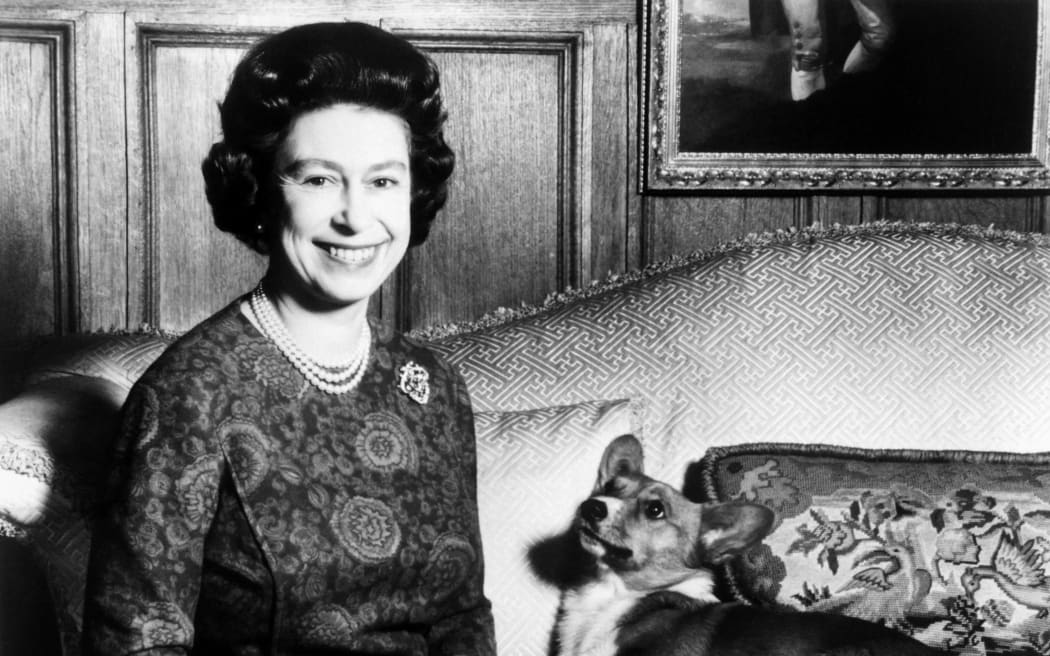 Queen Elizabeth II poses with one of her corgi dogs in a photo taken on 26 February, 1970.