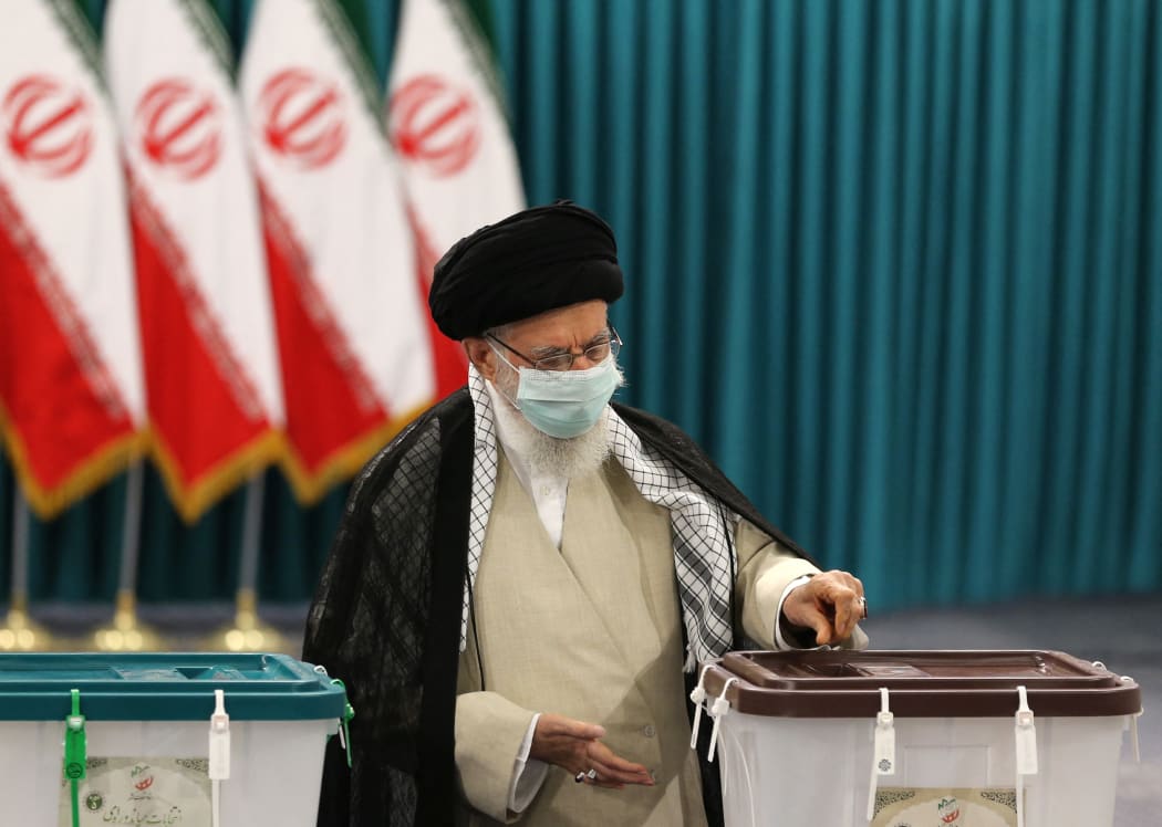 Iran's Supreme Leader Ayatollah Ali Khamenei wears a face mask as he casts his ballot on June 18, 2021.
