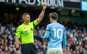 Jack Grealish of Manchester City receives a yellow card from the referee