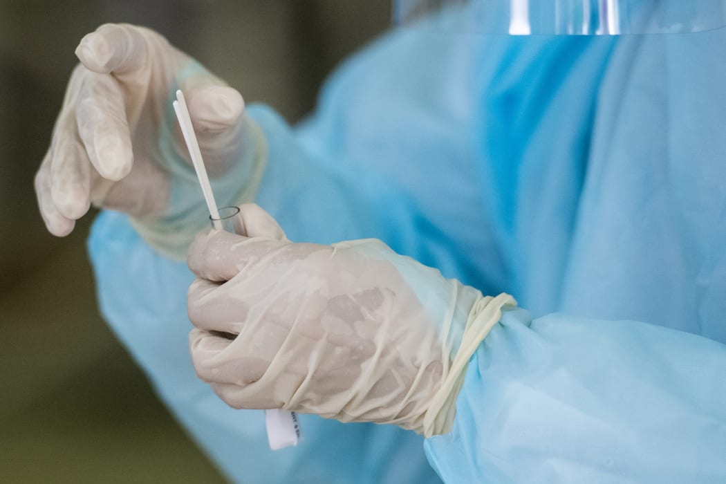A health worker puts swabs into a tube after collecting a sample for Covid-19 testing at Sunway Medical Center in Subang Jaya, on the outskirts of Kuala Lumpur, on October 22, 2020.