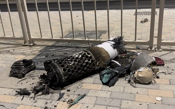 This frame grab taken from AFPTV footage shows the remnants of an Iranian missile intercepted over Qatar, as it lies on a pavement near a fence on June 23, 2025. Qatar said on June 23, the security situation was "stable" following an Iranian missile attack that targeted a US base on its territory in retaliation for American attacks on Iran nuclear sites.