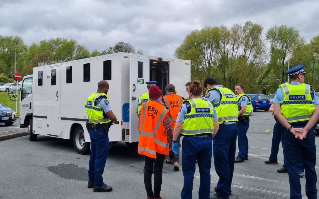 Melling motorway protesters are loaded into a police van.