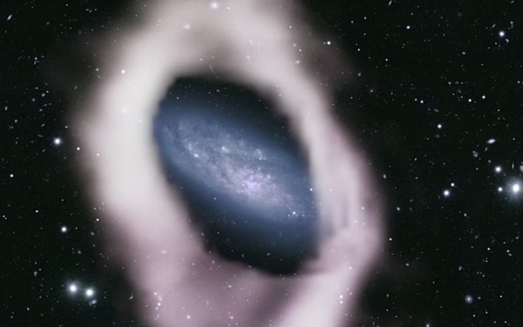 A colourised radio telescope image of the central disk of NGC 4632 surrounded by a thick band of hydrogen gas (white).