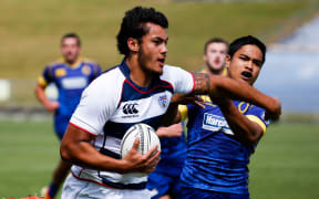 Auckland's Tain Lam fends off a tackler