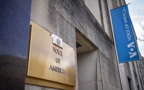 Signage for US broadcaster Voice of America is seen in Washington, DC, on March 16, 2025. US President Donald Trump's administration on March 15 put journalists at Voice of America and other US-funded broadcasters on leave, abruptly freezing decades-old outlets long seen as critical to countering Russian and Chinese information offensives. (Photo by BONNIE CASH / AFP)