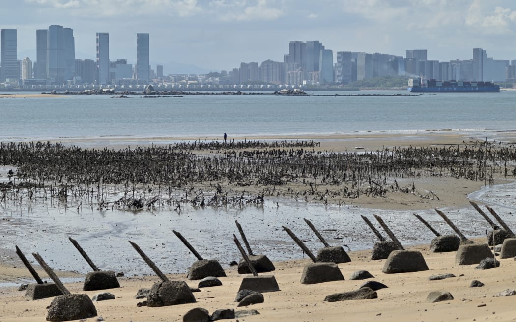 The Xiamen city skyline on the Chinese mainland is seen past anti-landing spikes placed along the coast of Lieyu islet on Taiwan's Kinmen islands, which lie just 3.2km from the mainland China coast, on 10 August 2022.