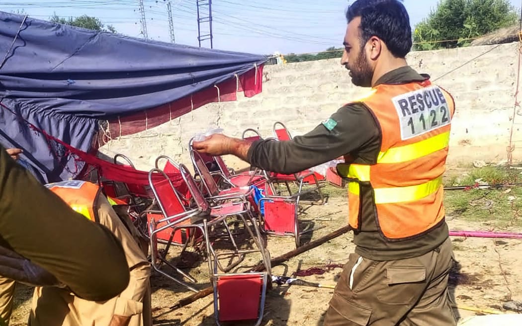 This handout photograph released by Pakistan's Emergency Rescue 1122 Service on 30 July  2023 shows rescue workers at the site of a bomb blast in Bajaur district, in Pakistan's Khyber Pakhtunkhwa province.