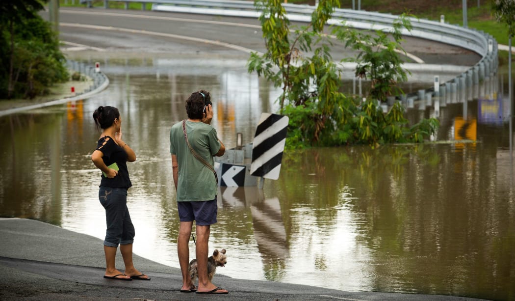 Residents watch as floodwaters caused by Cyclone Debbie recede in Beenleigh on April 2, 2017.
