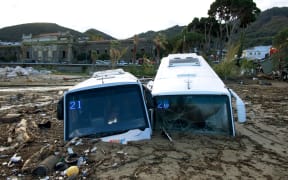 Damaged tourist buses are seen at the port of Casamicciola, following heavy rains that caused a landslide on the island of Ischia, southern Italy. Italian rescuers were searching for a dozen missing people on the southern island of Ischia after a landslide killed at least one person, as the government scheduled an emergency meeting. A wave of mud and debris swept through the small town of Casamicciola Terme early Saturday morning, engulfing at least one house and sweeping cars down to the sea, local media and emergency services said.