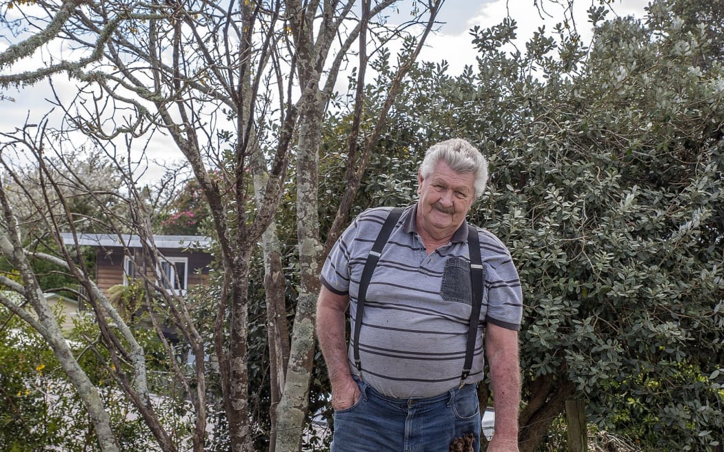 Riverside Drive resident Don Meads and dog Banjo near the kōwhai tree planted on the stopbank behind his house.