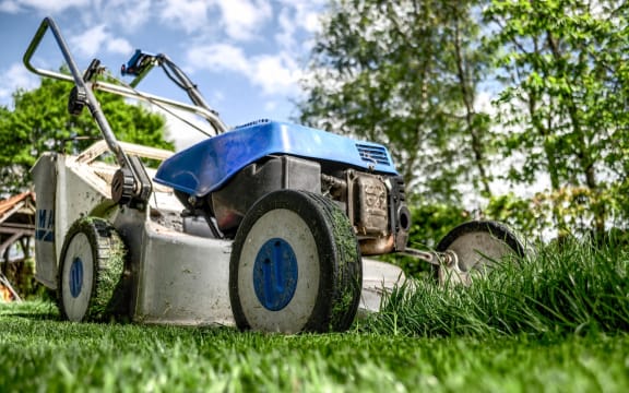 A lawnmower cutting grass