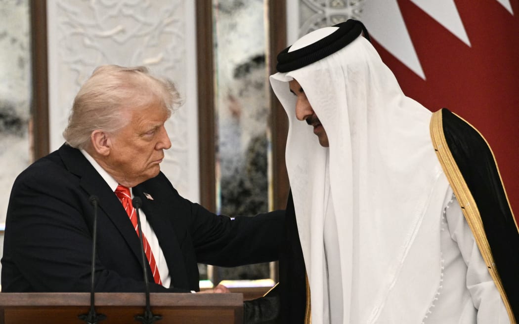 Qatar's Emir Sheikh Tamim bin Hamad al-Thani shakes the hand of the US President Donald Trump (L) at the start of a state dinner at the Lusail Palace in Doha on May 14, 2025. (Photo by Brendan SMIALOWSKI / AFP)