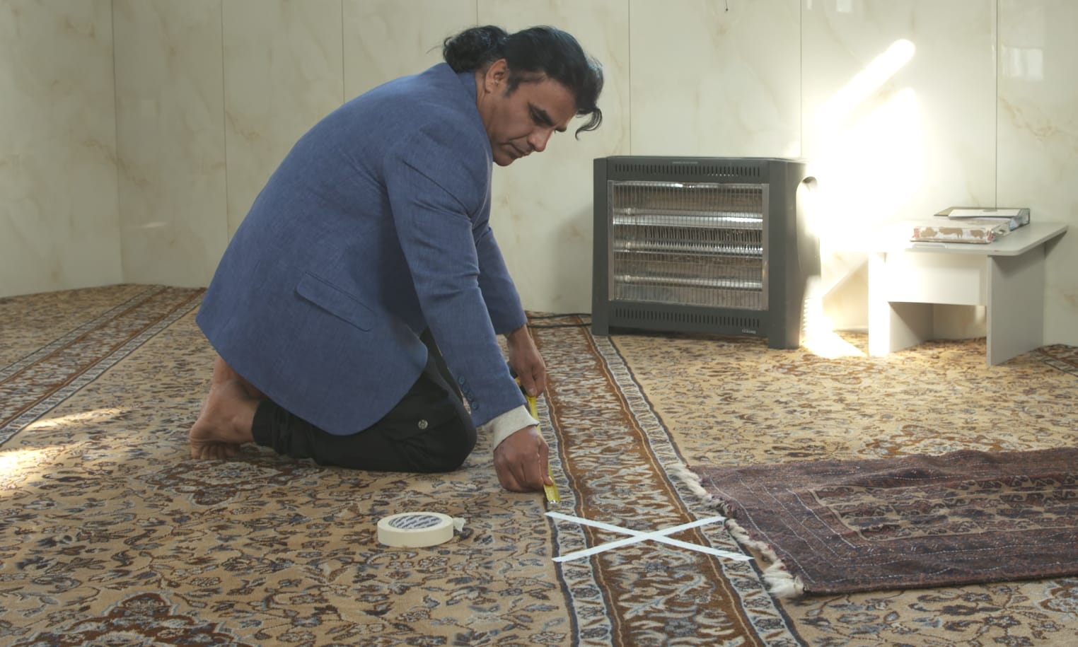 Abdul Aziz places markers designed to maintain distance between worshippers at Linwood mosque.