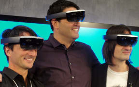 Microsoft executives Joe Belfiore, Terry Myerson and Alex Kipman pose wearing HoloLens eyewear that overlays 3D images on the real world.