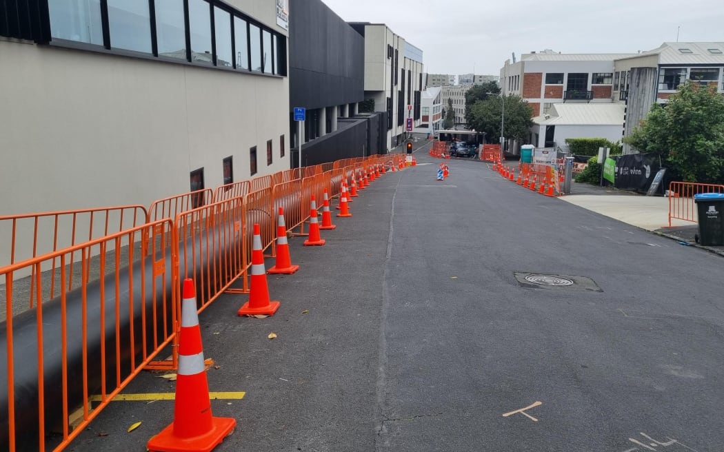 Road cones line St Georges Bay Road in the Auckland suburb of Parnell where a sewer line collapsed in September 2023.