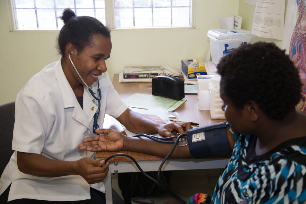 Rose (mother) and toddler in the treatment room at Susa Mama health clinic, Port Moresby General Hospital, PNG
