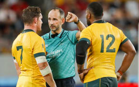 Michael Hooper and Samu Kerevi  listen to French referee Romain Poite during the Japan 2019 Rugby World Cup match between Australia and Wales at the Tokyo Stadium in Tokyo.