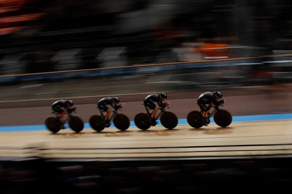 A New Zealand track cycling team of 4 riders cycle in the velodrome.