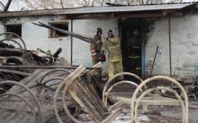 Firefighters work among the debris of a psychiatric hospital destroyed by the fire in the village of Alfyorovka on December 13, 2015, in the latest tragedy to hit mental health hospitals in the country. AFP PHOTO / ANDREI ARKHIPOV
