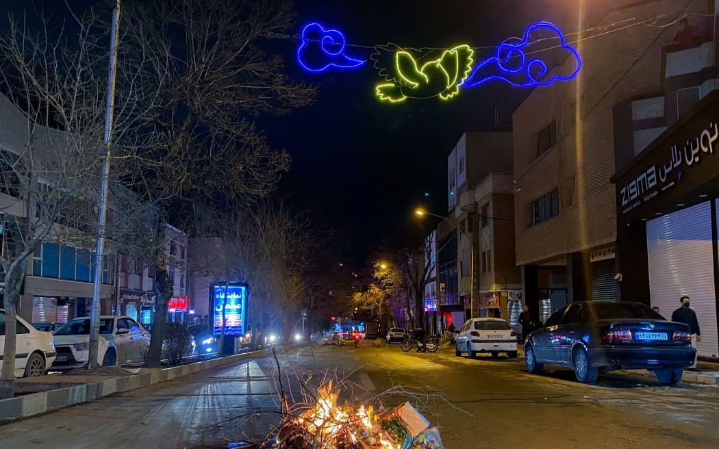 Burning debris lies in the middle of a street during unrest in Hamedan, Iran.