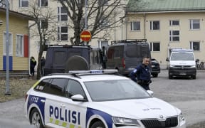 Finnish police officers and police vehicles are seen at the primary Viertola comprehensive school where a child opened fire and injured three other children.