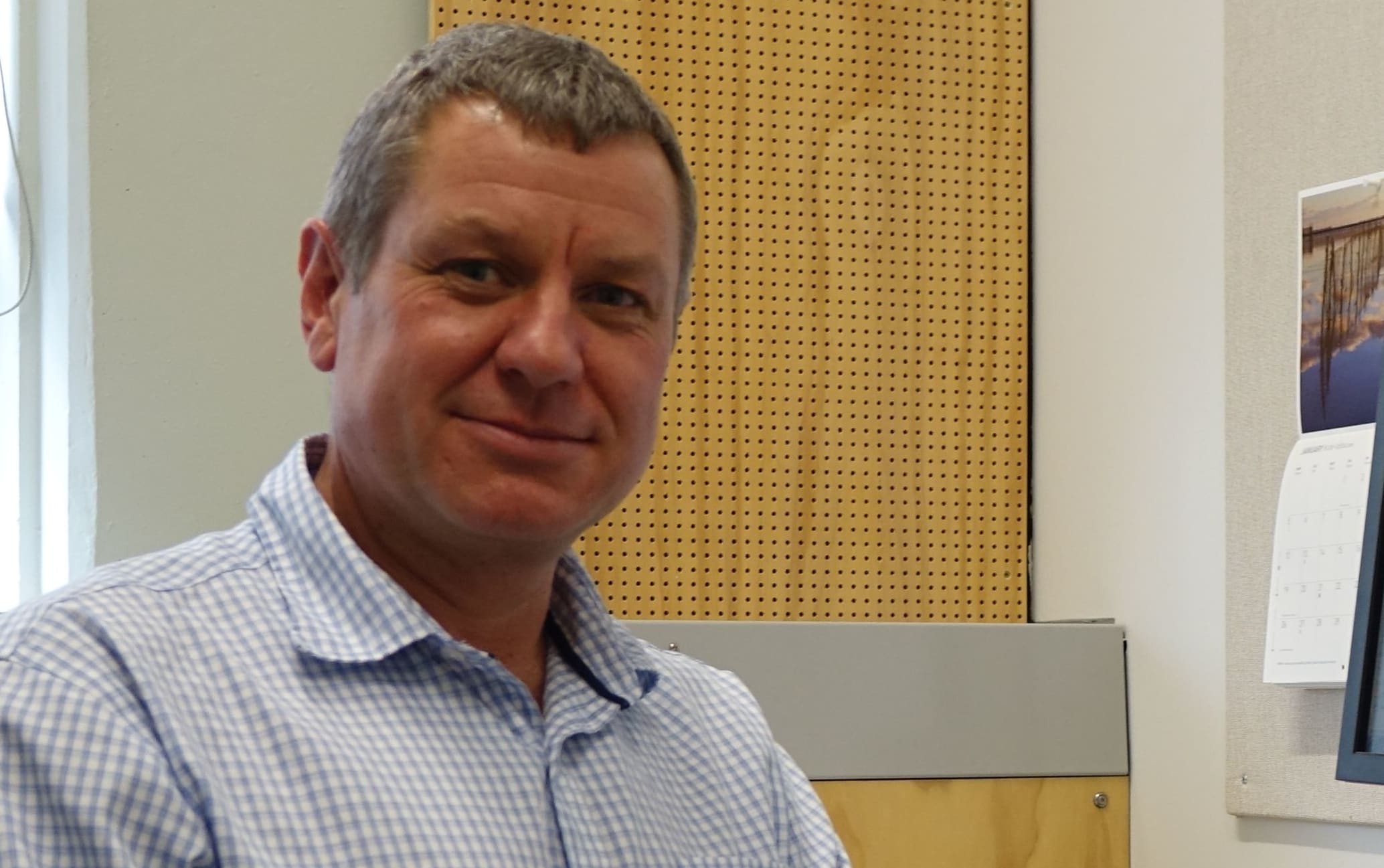 Professor sits in front of screen in his office