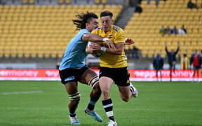 Cameron Roigard of the Hurricanes is tackled by Charlie Gamble of the Waratahs