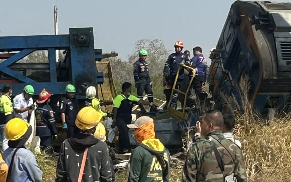 This UGC handout photo courtesy of Facebook user Smith Mikle taken and released on January 14, 2026 shows rescue workers next to the wreckage of a train crash after a construction crane collapse in Thailand's Nakhon Ratchasima province. A crane at an under-construction high-speed rail line in Thailand collapsed onto a passenger train on January 14, causing it to derail and killing at least 22 people, local authorities said. (Photo by Handout / Courtesy of Facebook user Smith Mikle / AFP) / NO USE AFTER JANUARY 24, 2026 05:20:07 GMT - NO USE AFTER JANUARY 24, 2026 05:20:07 GMT - RESTRICTED TO EDITORIAL USE – MANDATORY CREDIT «  AFP PHOTO / COURTESY OF FACEBOOK USER SMITH MIKLE » - NO MARKETING NO ADVERTISING CAMPAIGNS – DISTRIBUTED AS A SERVICE TO CLIENTS - NO ARCHIVE /