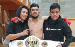 Taunga Kairena with his championship belt and peers